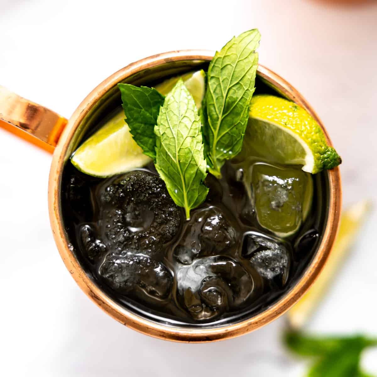 Overhead of copper mug with Mexican mule garnished with mint leaves. 