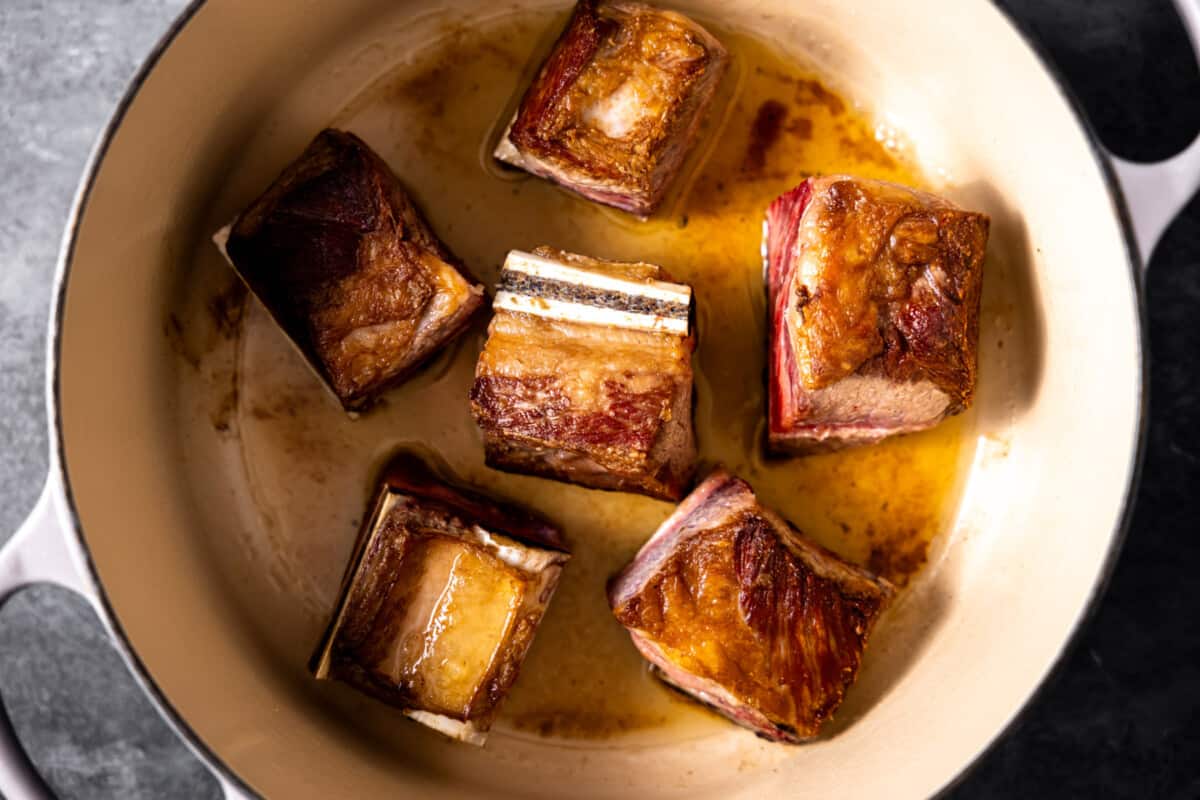 Searing bone in short ribs in a braising pan.