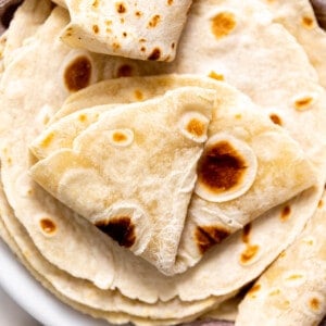 Plate filled with homemade flour tortillas.