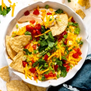 Taco dip in a white dish served with tortilla chips.