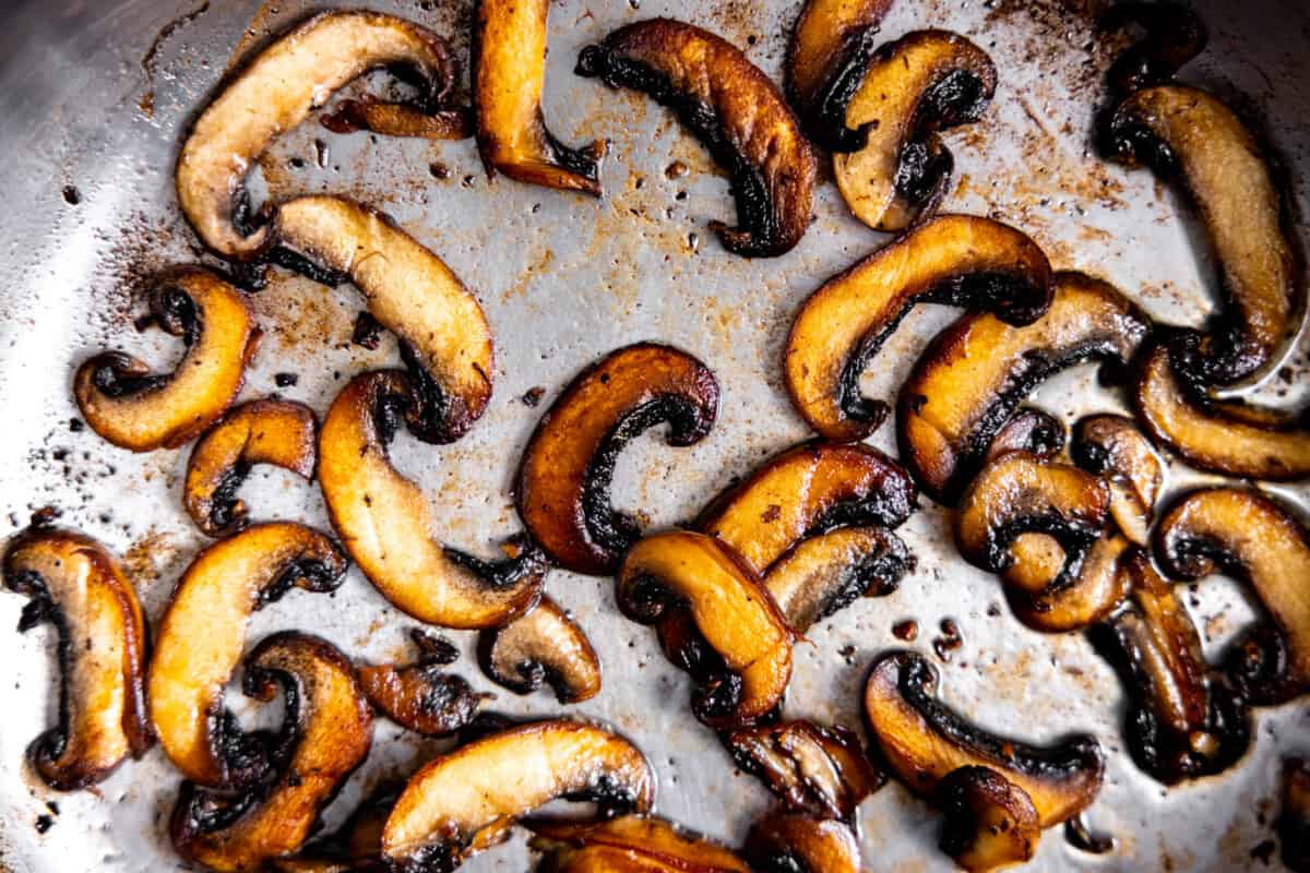 Mushrooms being cooked in a skillet. 