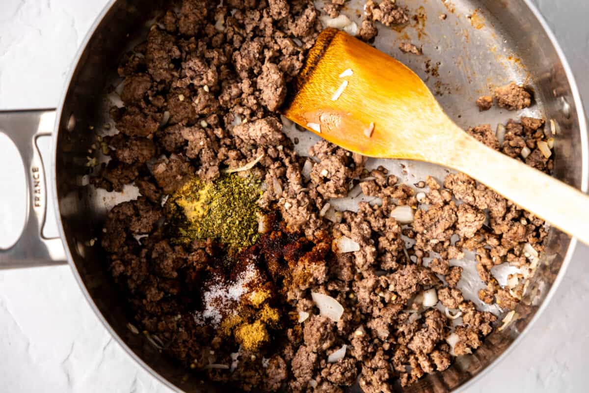 Ground beef being cooked in a skillet with taco seasonings.