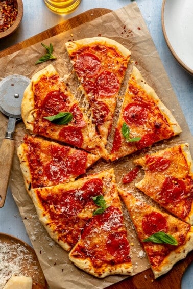 Sliced pepperoni pizza with fresh basil on top.