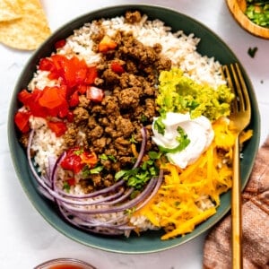 Taco bowl served over rice topped with sour cream.