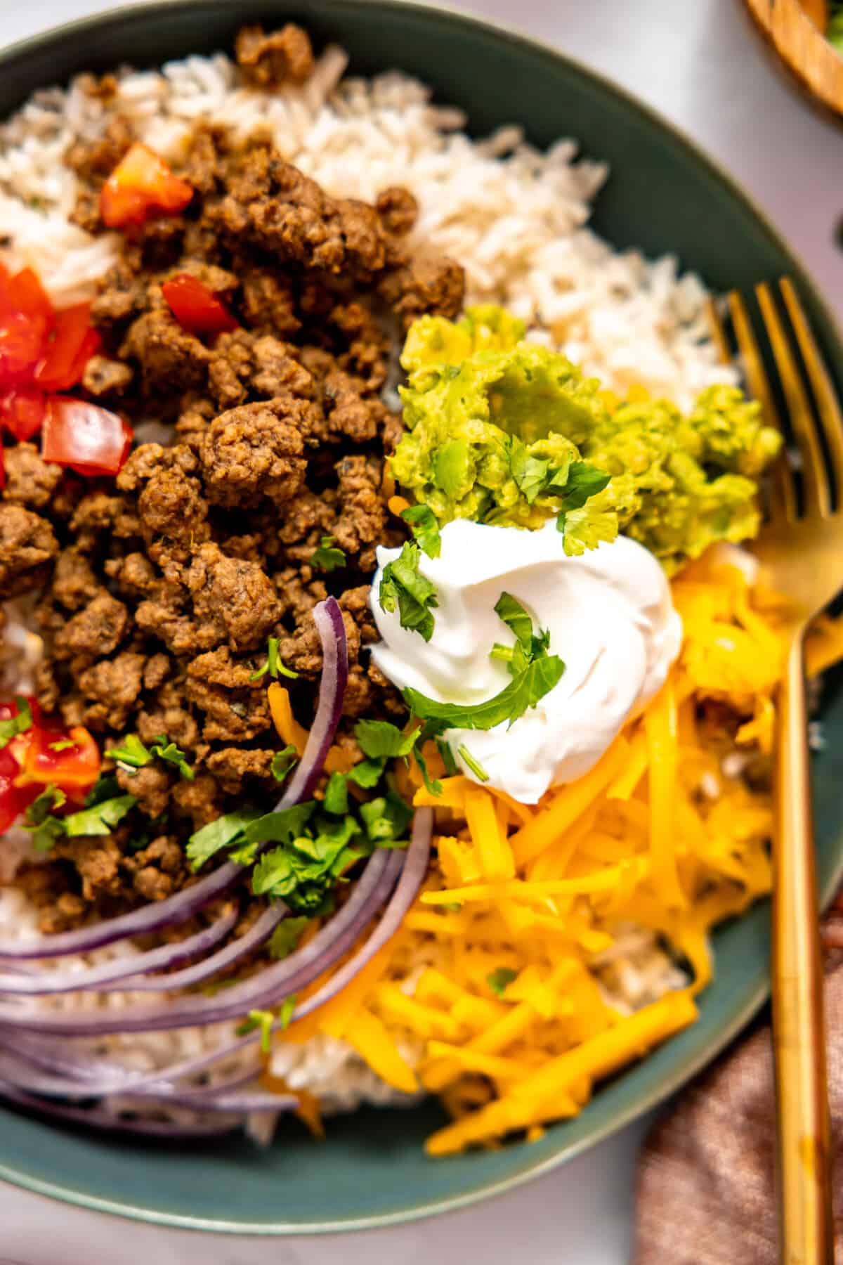 Taco bowl with guacamole and sour cream on top.