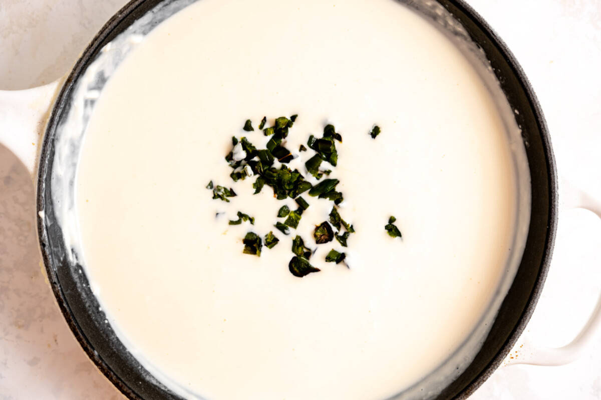 Skillet with white queso and roasted jalapeno added. 