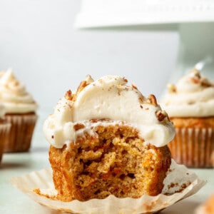 Carrot cake cupcake with a bite taken out.