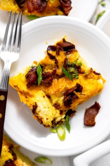 Plate with a slice of bacon and cheese strata.