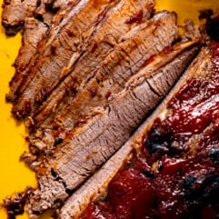 Sliced beef brisket with bbq sauce.