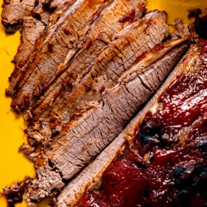 Sliced beef brisket with bbq sauce.