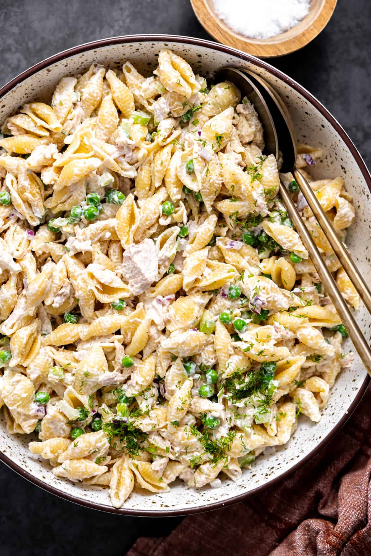 Bowl of tuna pasta salad with spoons for serving. 