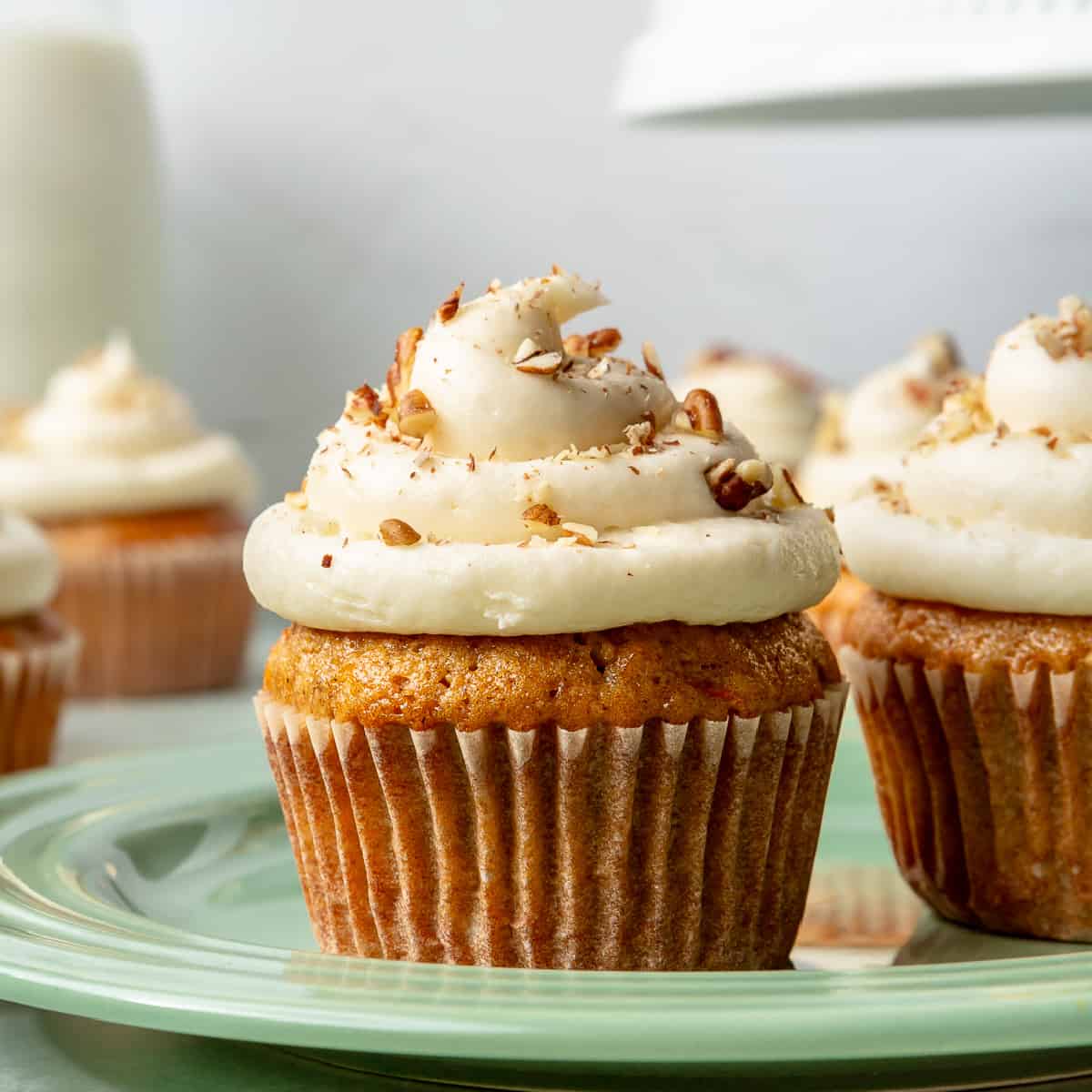Carrot cake cupcakes with cream cheese frosting swirl.
