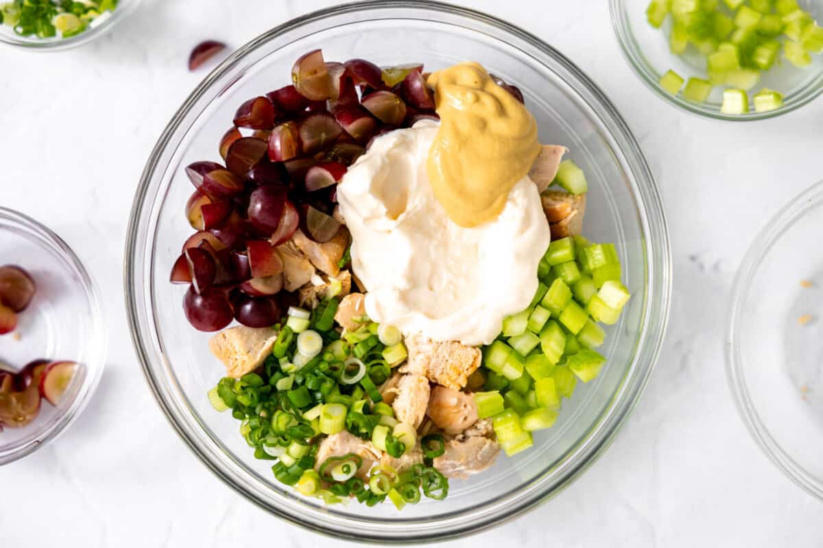 Ingredients for chicken salad with mayo and mustard being added. 