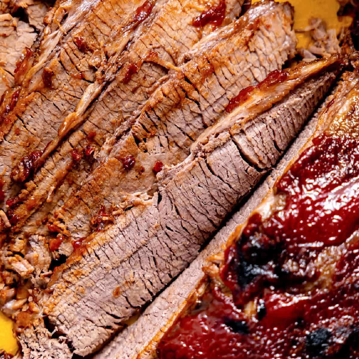 Sliced beef brisket with BBQ sauce.