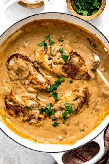 Skillet with cream of mushroom chicken topped with fresh herbs.