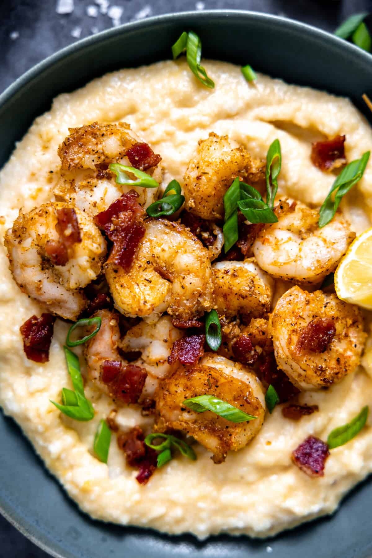 Shrimp and grits served in a bowl topped with fresh parsley.