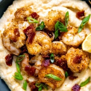 Shrimp and grits served in a bowl topped with fresh parsley.