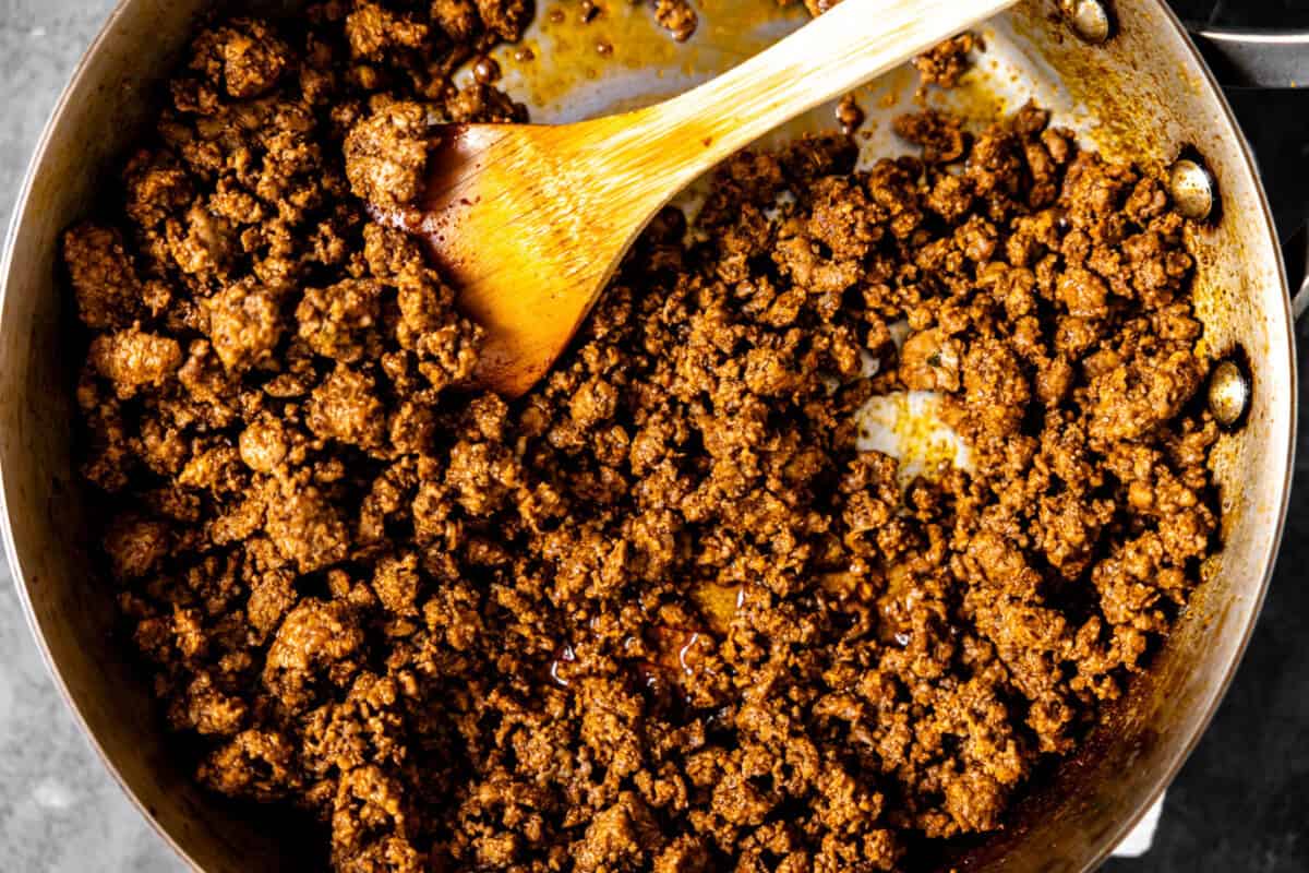 Taco meat being cooked in a skillet. 