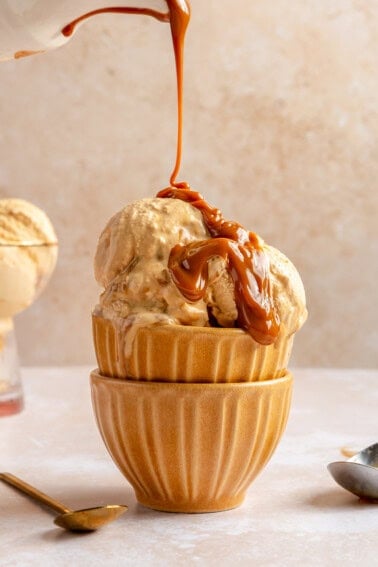 Drizzling caramel on a bowl of homemade ice cream.