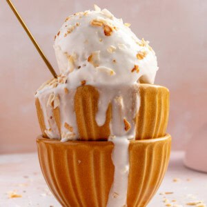 Stacked bowls with coconut sorbet topped with toasted flakes of coconut.