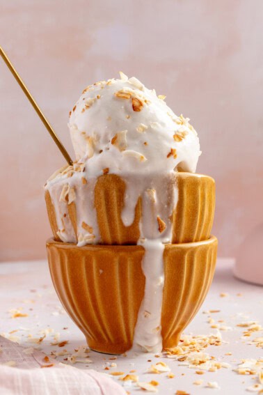 Stacked bowls with coconut sorbet topped with toasted flakes of coconut.