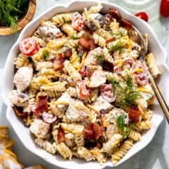 Chicken bacon ranch pasta in a bowl topped with fresh herbs.