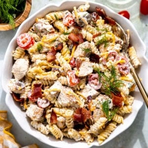 Chicken bacon ranch pasta in a bowl topped with fresh herbs.