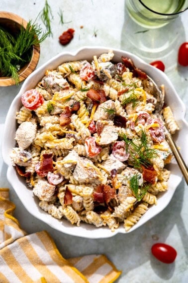 Chicken bacon ranch pasta in a bowl topped with fresh herbs.