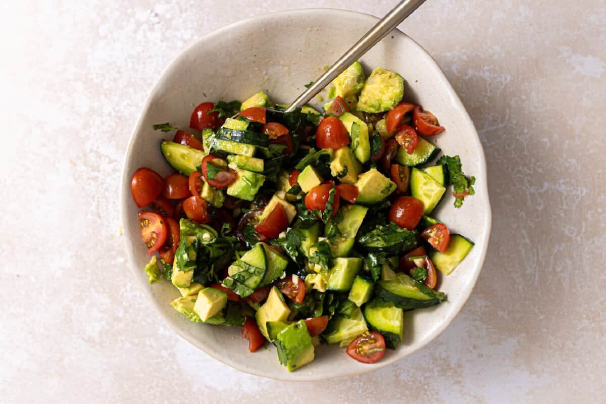 Avocado, Tomato, and cucumber salad in a bowl.