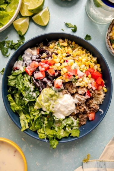 Mexican bowl with rice, beans, corn, and lettuce.